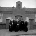 Het beeld van St. Michaël op zijn oorspronkelijke stek, een nis in de westgevel van de school (SALHA, fotonr. 81604, foto J. de Bont, januari 1956).